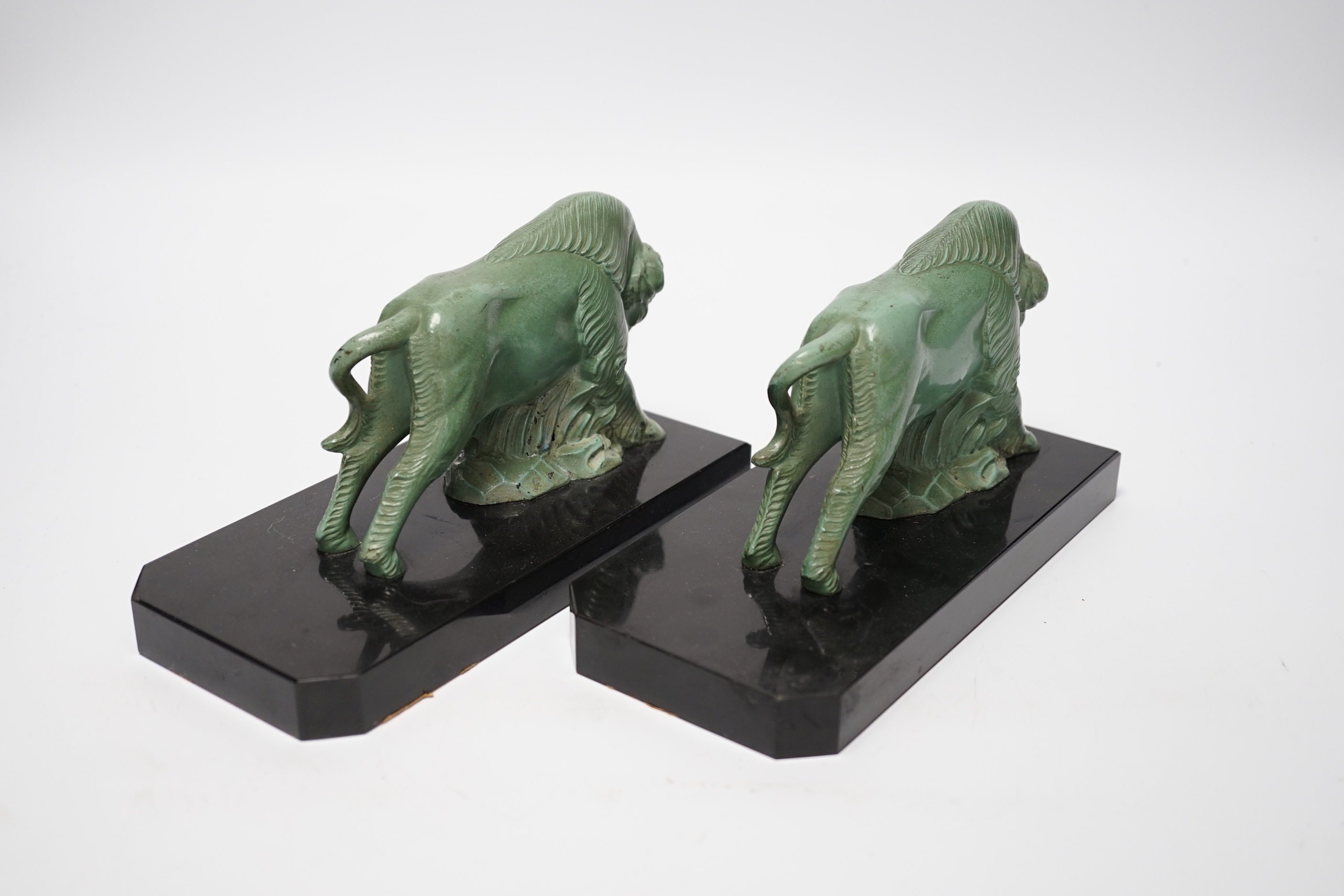 A pair of early 20th century green patinated spelter ‘bison’ book-ends, 19cm long